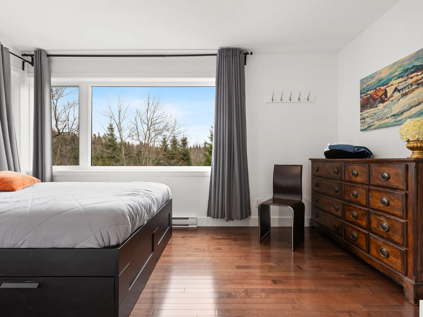 Chambre du chalet Le Haut Perché avec lit queen, commode et vue sur la forêt