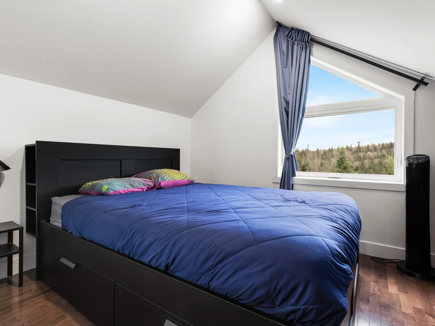Chambre en mezzanine du chalet Le Haut Perché avec lit queen et fenêtre donnant sur la nature